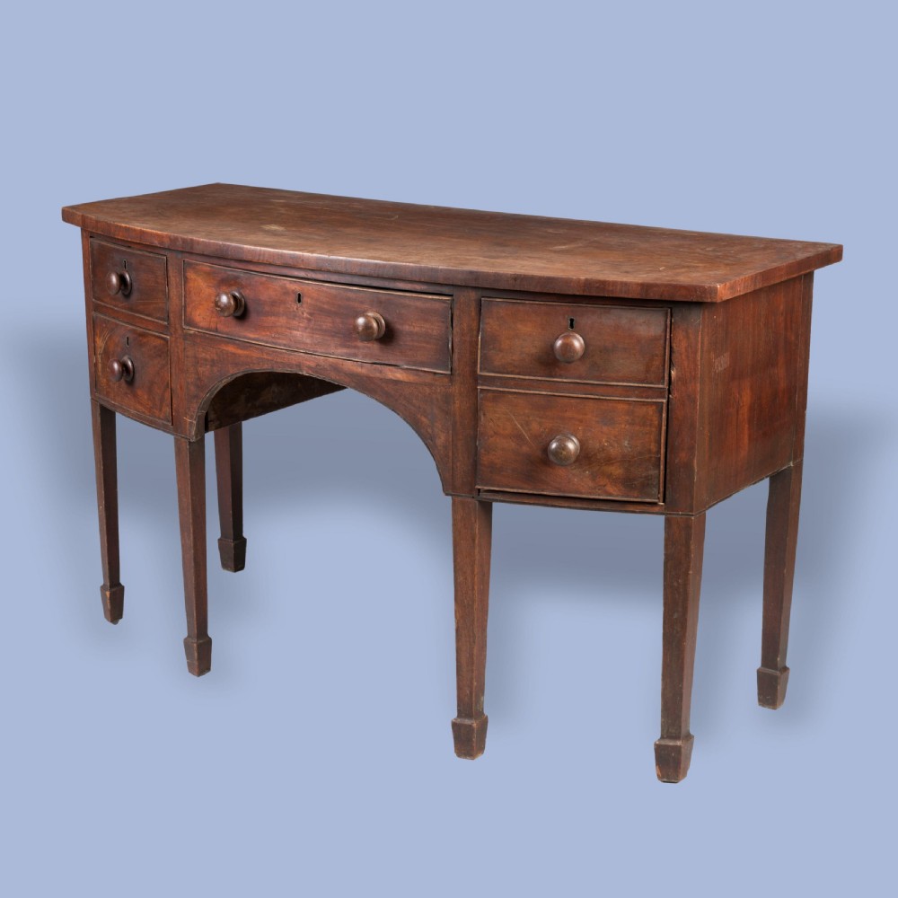 A Georgian mahogany bowfront sideboard featuring a central drawer flanked by side drawers, supported on square tapered legs with spade feet. View VII