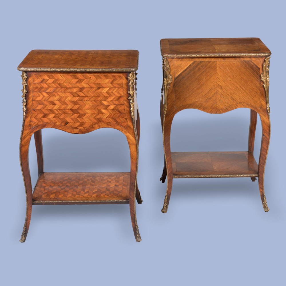 A matched pair of French Louis XV style wooden bedside tables featuring geometric parquetry veneer, three drawers, gilt bronze mounts, and slender cabriole legs. View III