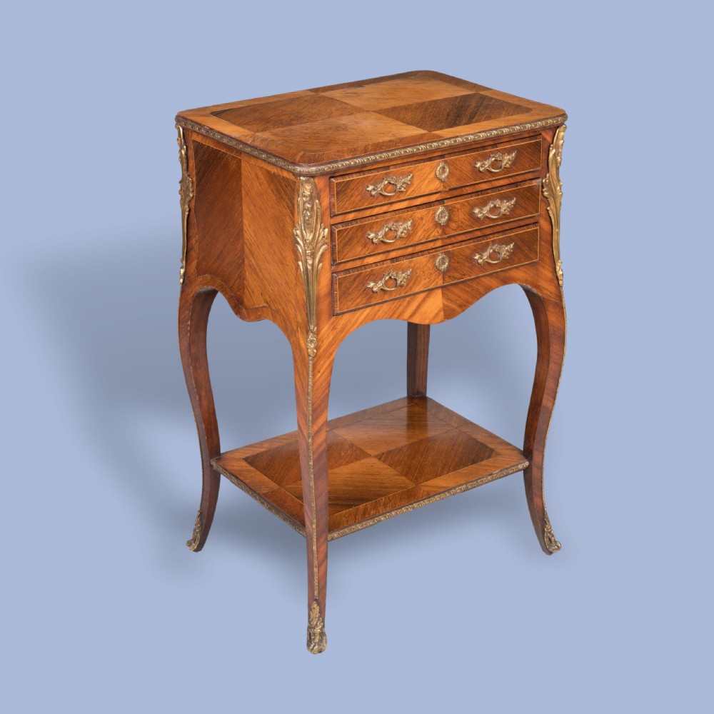 A matched pair of French Louis XV style wooden bedside tables featuring geometric parquetry veneer, three drawers, gilt bronze mounts, and slender cabriole legs. View VII