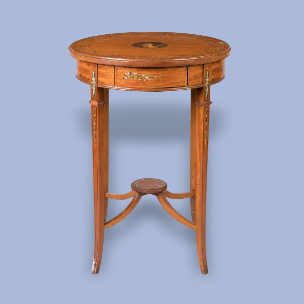 A round satinwood occasional table featuring hand-painted floral swags, tapered square legs, and a raised central stretcher. View II