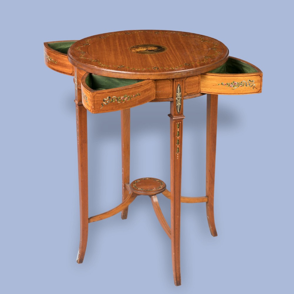 A round satinwood occasional table featuring hand-painted floral swags, tapered square legs, and a raised central stretcher. View IV