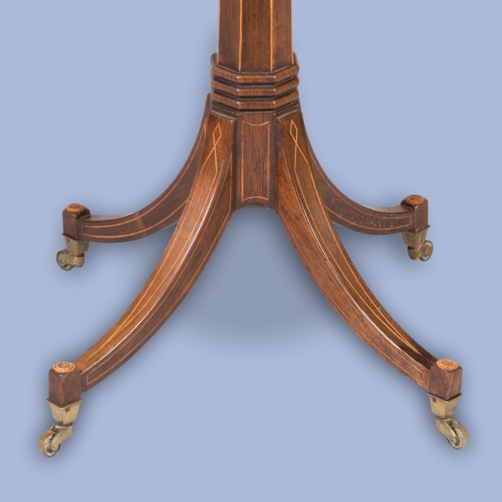 A small Regency mahogany drum table featuring a circular top with frieze drawers, supported on an inlaid central column and four swept legs with brass castors. View III