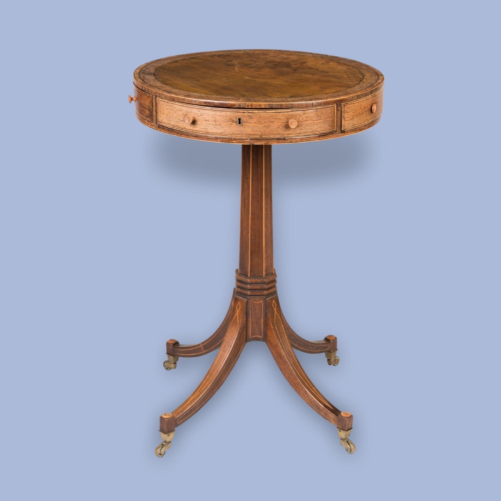 A small Regency mahogany drum table featuring a circular top with frieze drawers, supported on an inlaid central column and four swept legs with brass castors. View IV