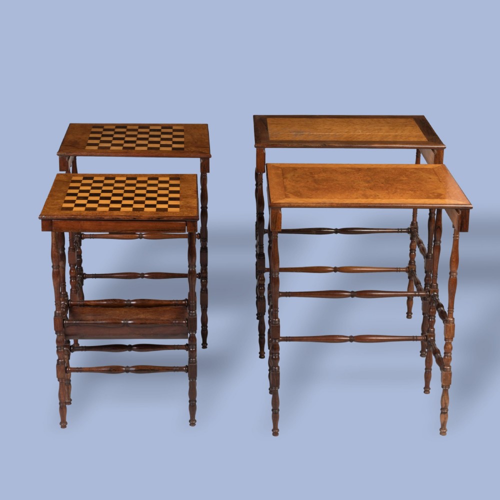 A set of four graduating brown rosewood quartetto tables featuring spindled legs and an inlaid chessboard top nested together. View IV