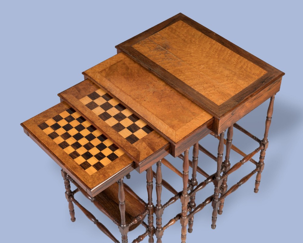 A set of four graduating brown rosewood quartetto tables featuring spindled legs and an inlaid chessboard top nested together. View V