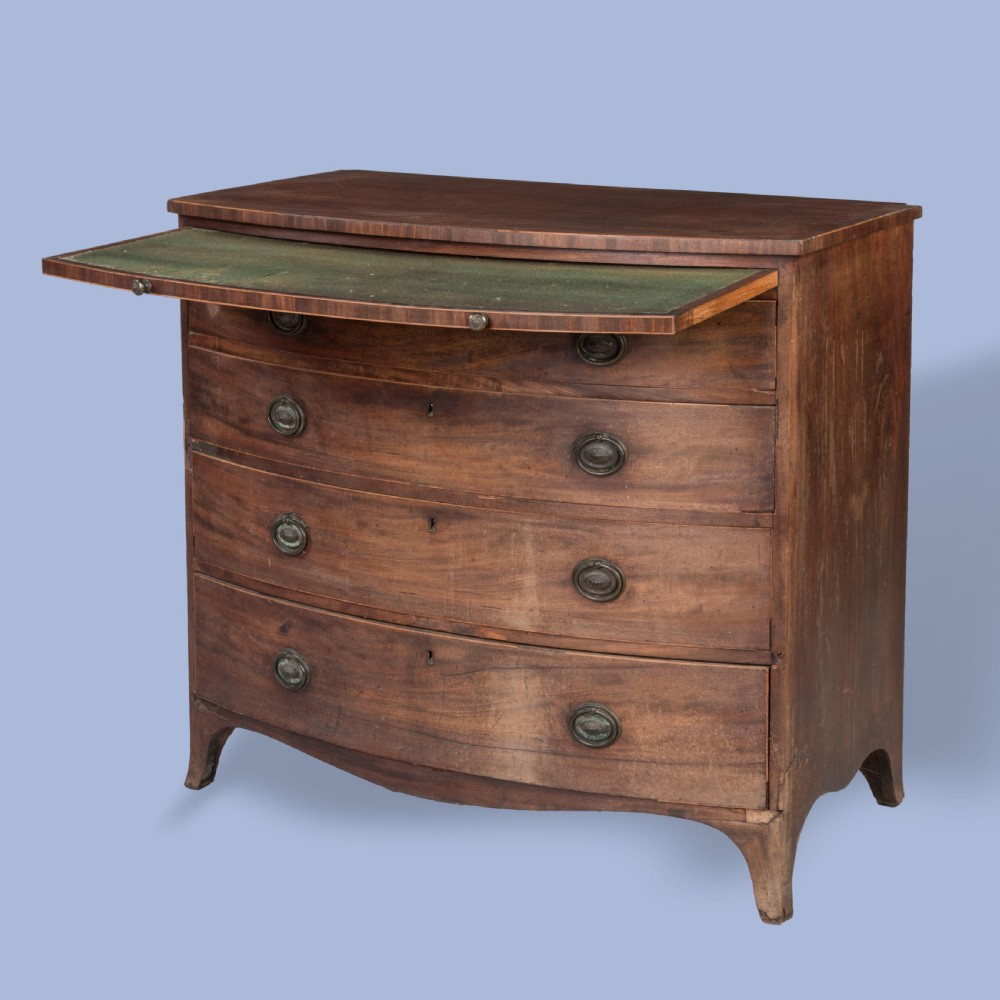 A George III mahogany bowfront chest featuring four graduated drawers with brass oval handles and splayed bracket feet. View VI
