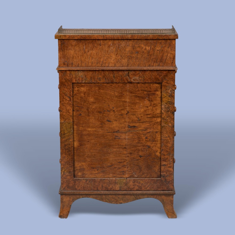 A late Georgian burr elm davenport desk featuring a sliding leather-topped writing slope with a brass gallery above stacked drawers with turned wooden knobs. View II
