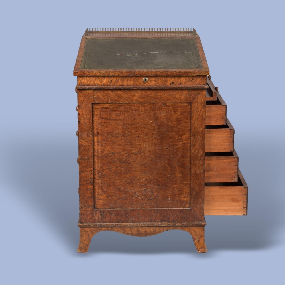 A late Georgian burr elm davenport desk featuring a sliding leather-topped writing slope with a brass gallery above stacked drawers with turned wooden knobs. View III