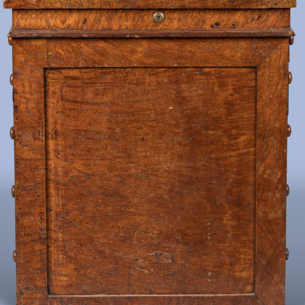 A late Georgian burr elm davenport desk featuring a sliding leather-topped writing slope with a brass gallery above stacked drawers with turned wooden knobs. View IV