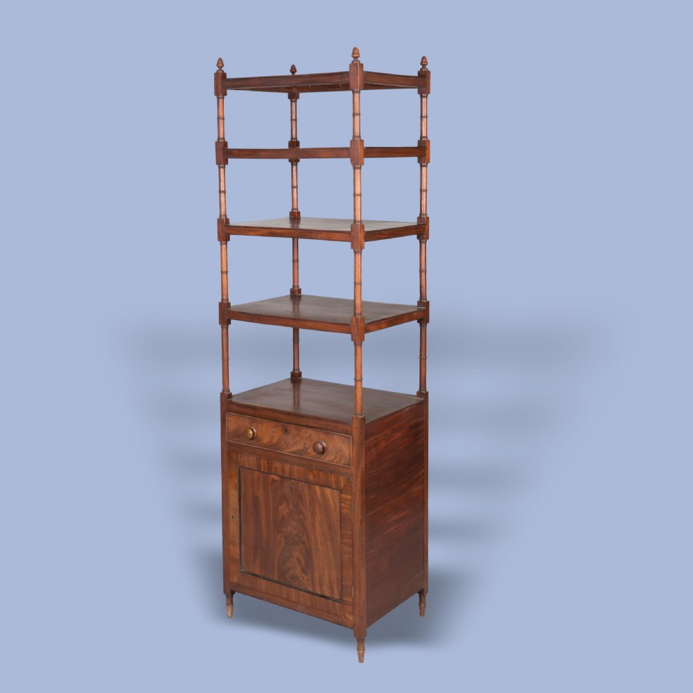 A tall George IV mahogany whatnot featuring four open tiers supported by turned columns above a single drawer and base cupboard.