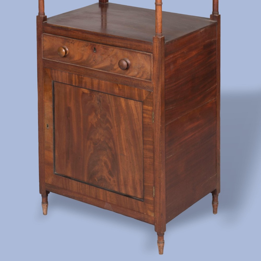 A tall George IV mahogany whatnot featuring four open tiers supported by turned columns above a single drawer and base cupboard. View IV