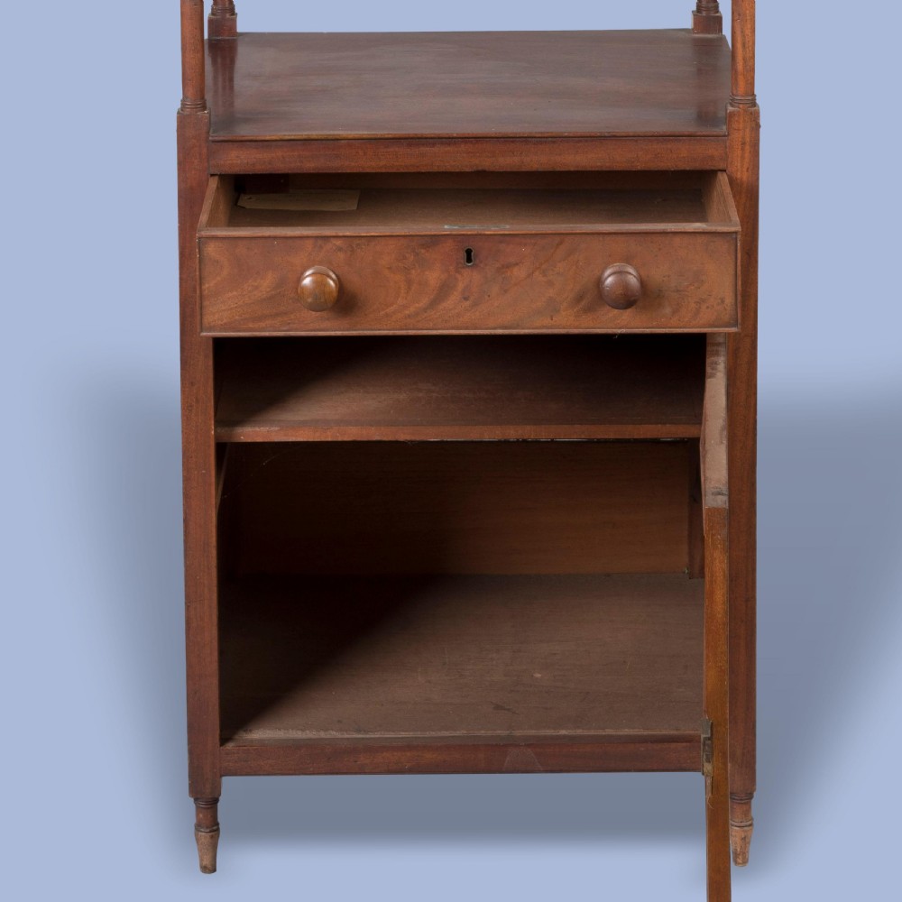 A tall George IV mahogany whatnot featuring four open tiers supported by turned columns above a single drawer and base cupboard. View V