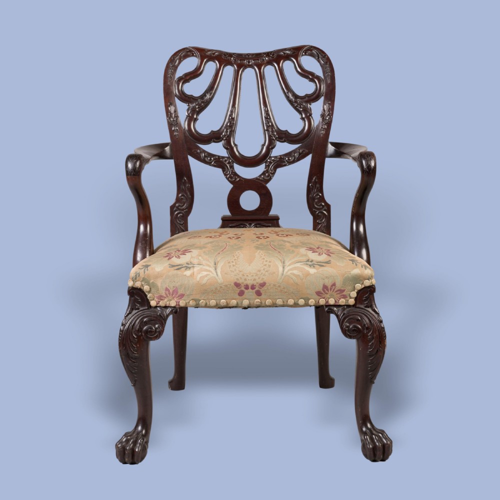 A dark mahogany open armchair featuring a carved pierced back splat, floral pattern upholstered seat, and cabriole front legs with ball-and-claw feet. View II