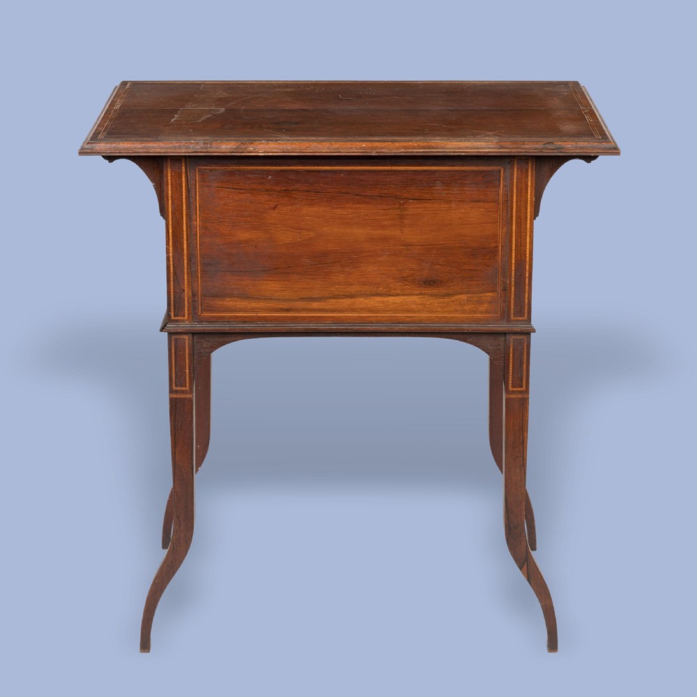 An Aesthetic Movement dark wood side table with detailed floral marquetry inlays on the drawers and slender curved legs. View IV