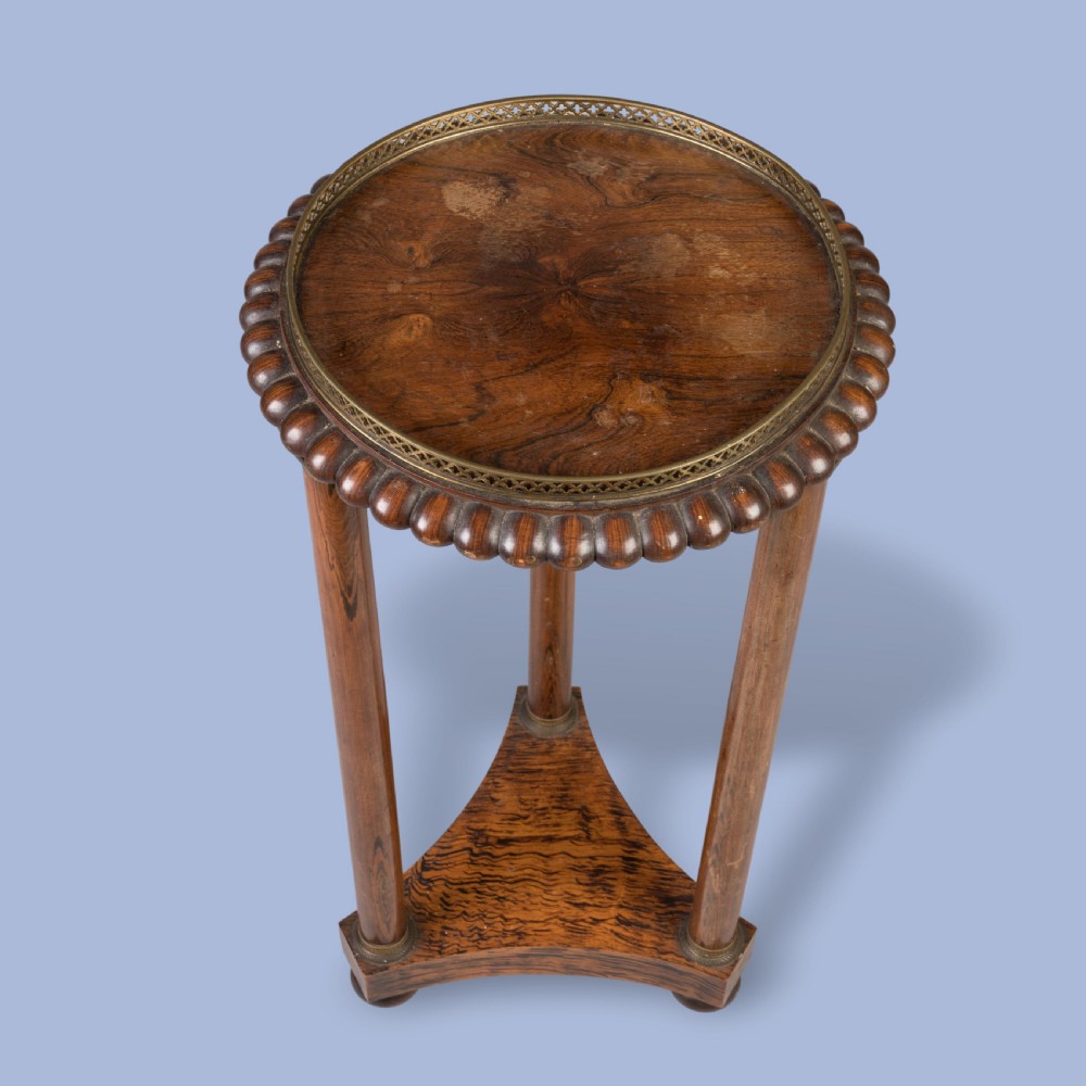 A pair of tall French Empire style mahogany pedestals featuring brass gallery rims, gadrooned tops, three cylindrical columns, and tri-form bases resting on bun feet. View IV