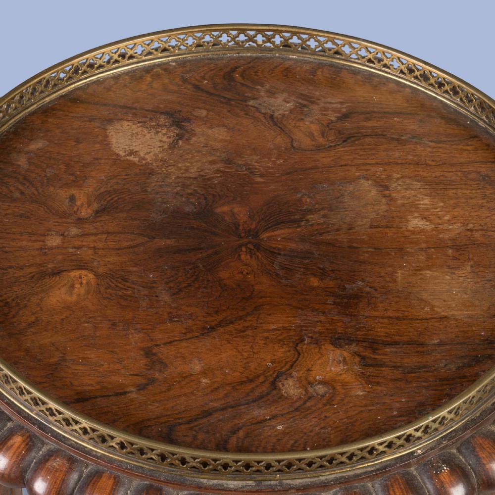 A pair of tall French Empire style mahogany pedestals featuring brass gallery rims, gadrooned tops, three cylindrical columns, and tri-form bases resting on bun feet. View V