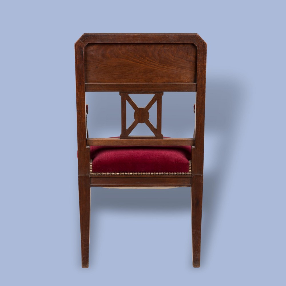 A pair of French Consulate style mahogany armchairs with red velvet upholstery, fluted front legs, and decorative brass star mounts. View III