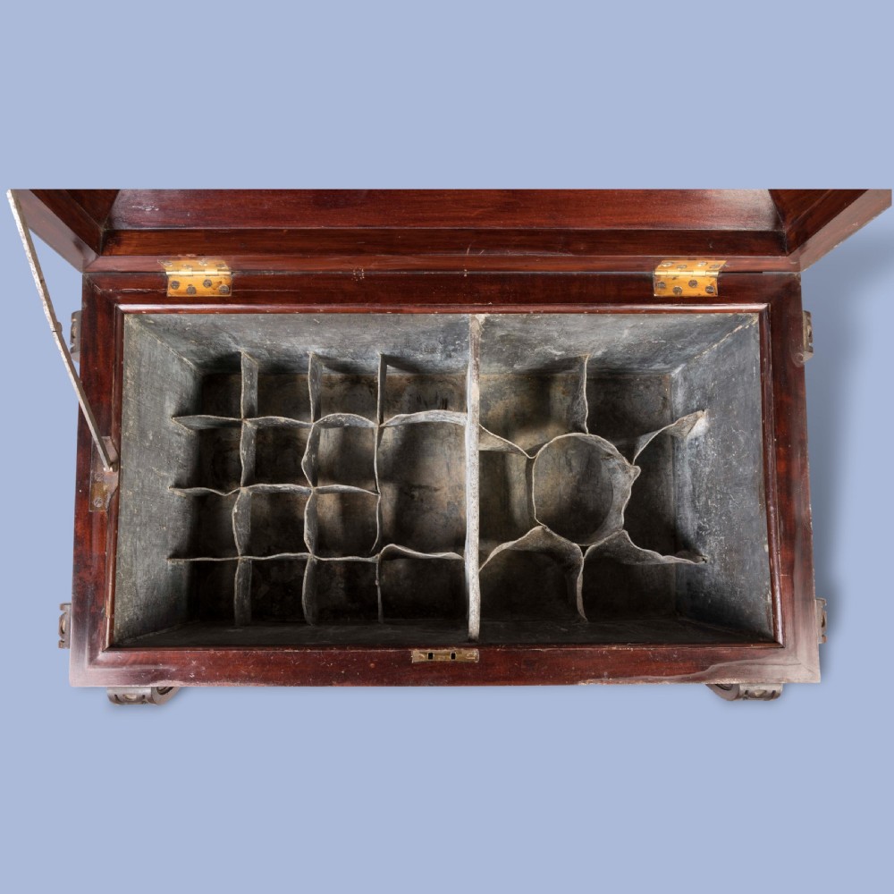 A William IV mahogany sarcophagus cellarette with carved scroll corner pilasters, panelled sides, and castors. View III