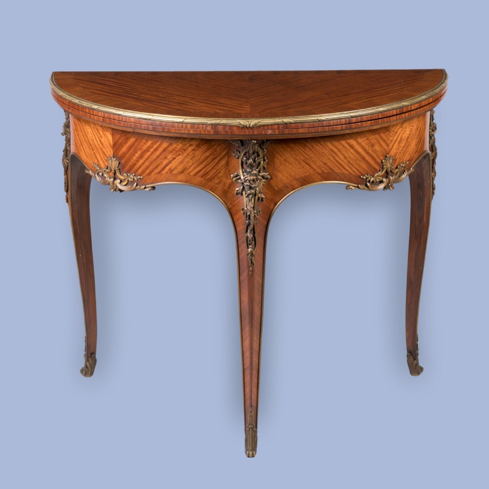 A French Louis XV style demilune kingwood card table featuring curved cabriole legs, intricate parquetry veneer, and decorative gilt-bronze mounts. View III