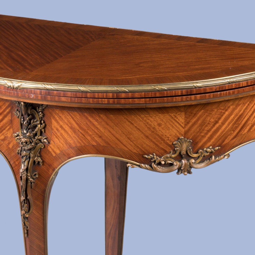 A French Louis XV style demilune kingwood card table featuring curved cabriole legs, intricate parquetry veneer, and decorative gilt-bronze mounts. View V