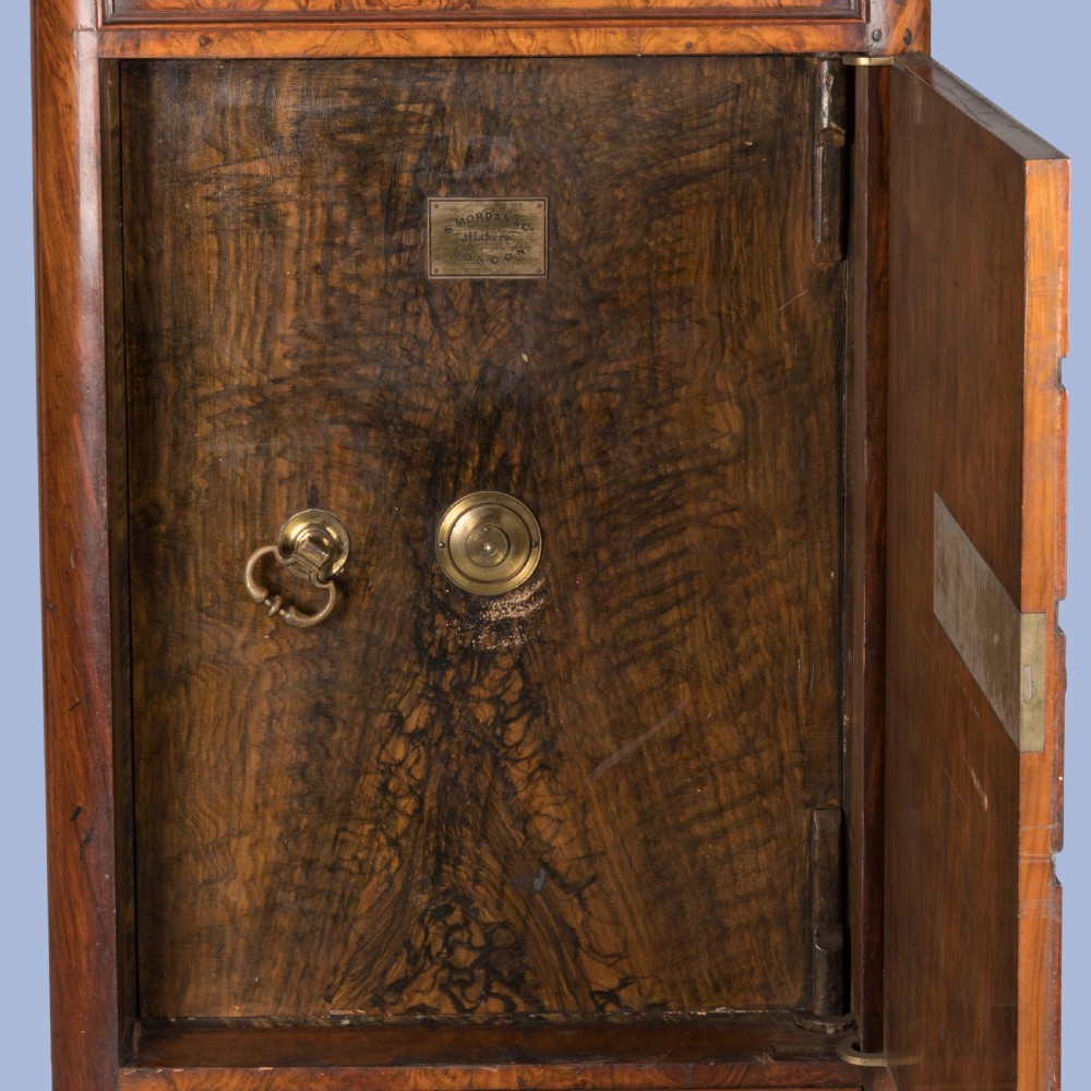 A tall Victorian burr walnut Wellington chest featuring seven graduated drawers, turned knobs, a locking side bar, and a plinth base. View VI