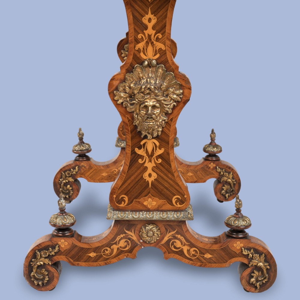 An ornate 19th-century French style marquetry writing table featuring a green leather top, gilt-bronze mounts, and scrolled end supports. View V