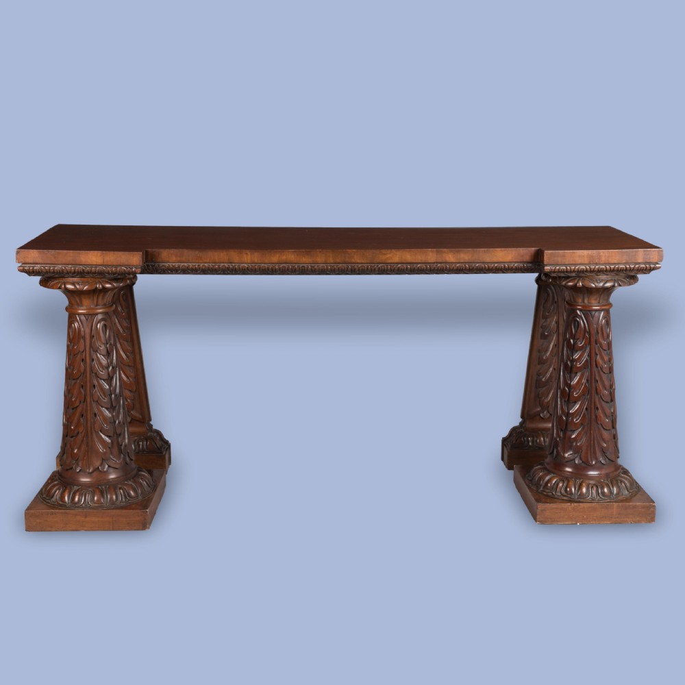 A William IV mahogany serving table featuring a rectangular top, gadrooned edge trimming, and acanthus leaf carved column supports on plinth bases. View II