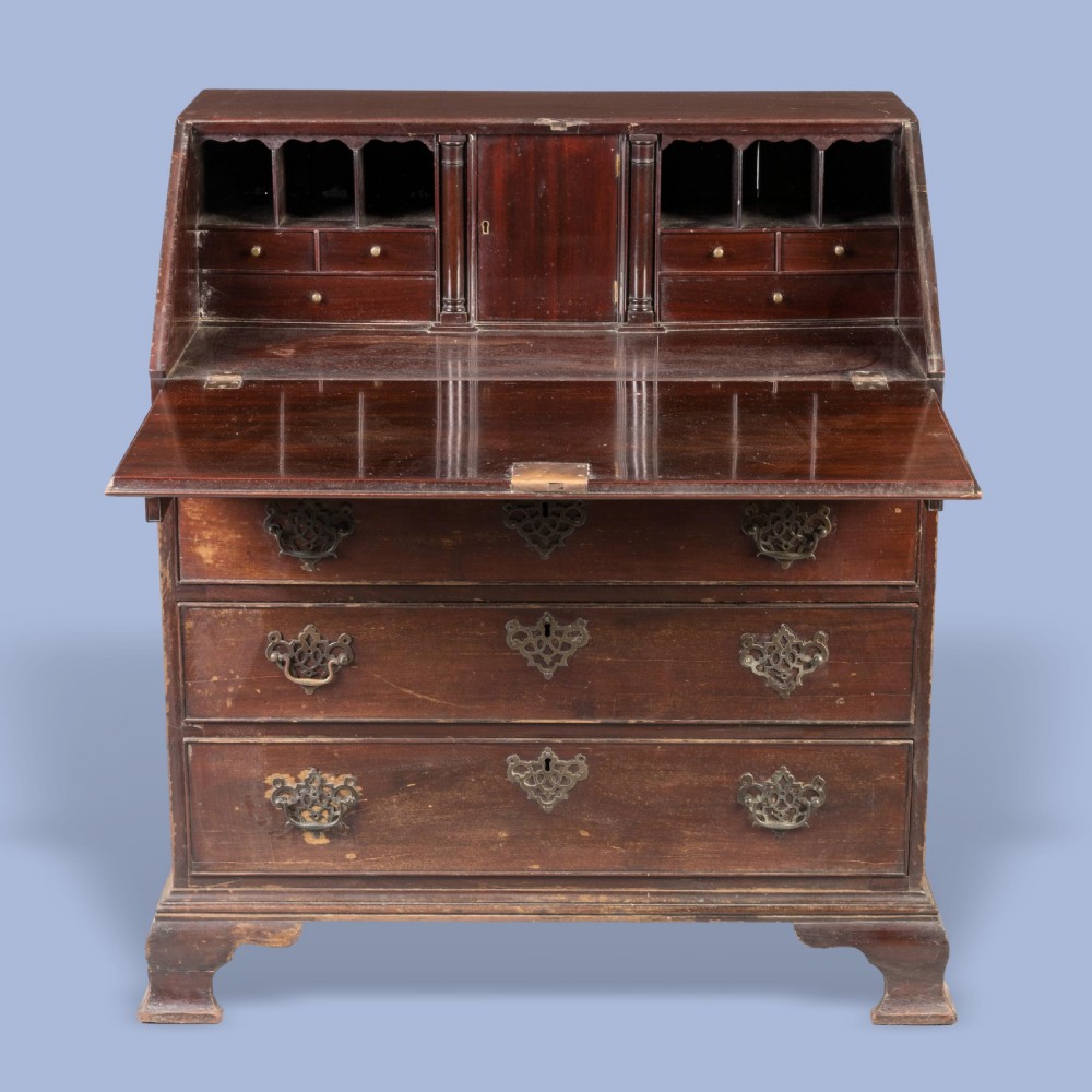 A Georgian mahogany slant-front writing bureau featuring four graduated drawers with decorative brass handles and bracket feet. View II