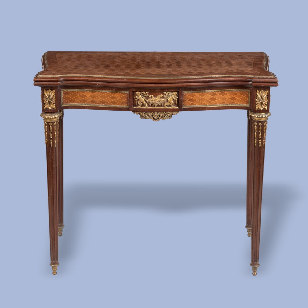 A rectangular Louis XVI style card table featuring geometric parquetry wood veneers, fluted tapering legs, and gilded ormolu mounts. View II