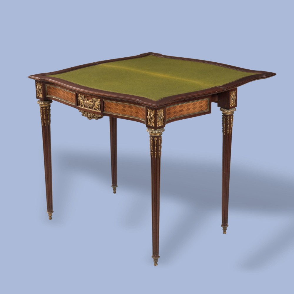 A rectangular Louis XVI style card table featuring geometric parquetry wood veneers, fluted tapering legs, and gilded ormolu mounts. View VI