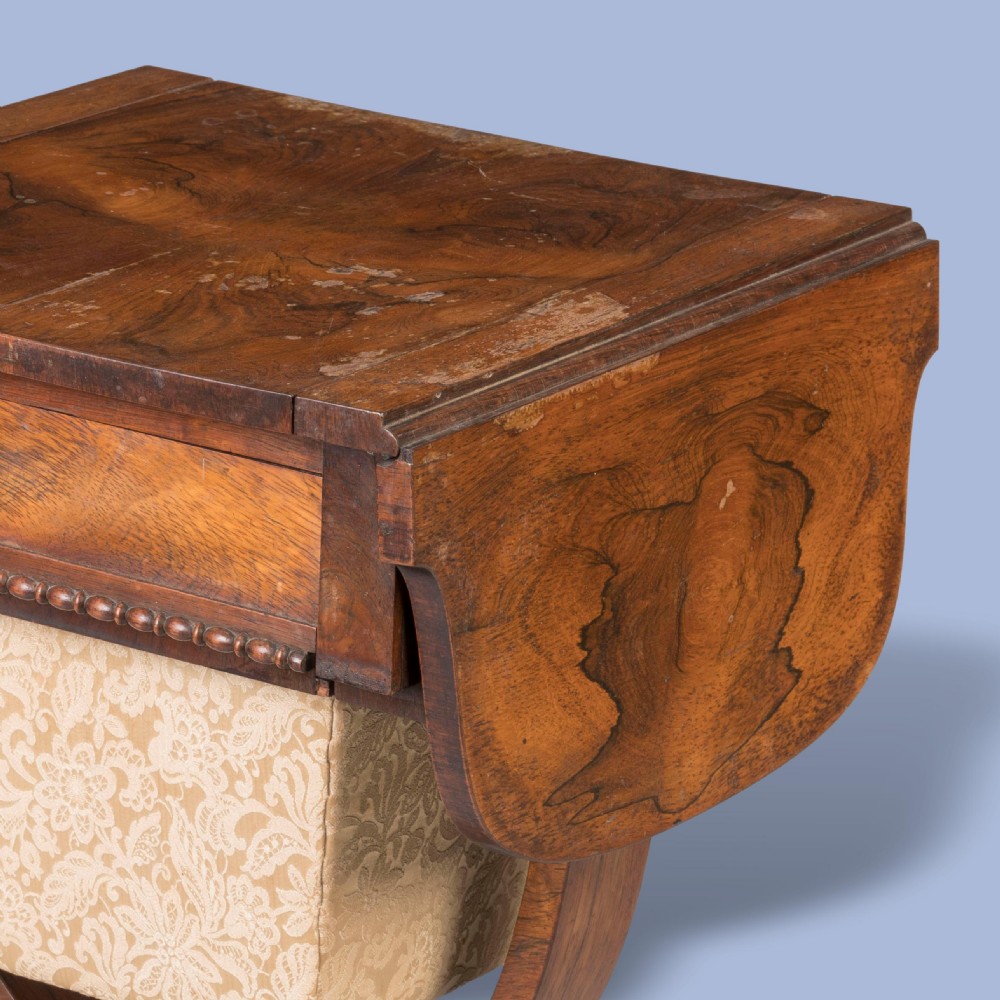 A William IV rosewood drop-leaf table with a fabric-covered work basket, U-shaped support, and carved claw feet. View III