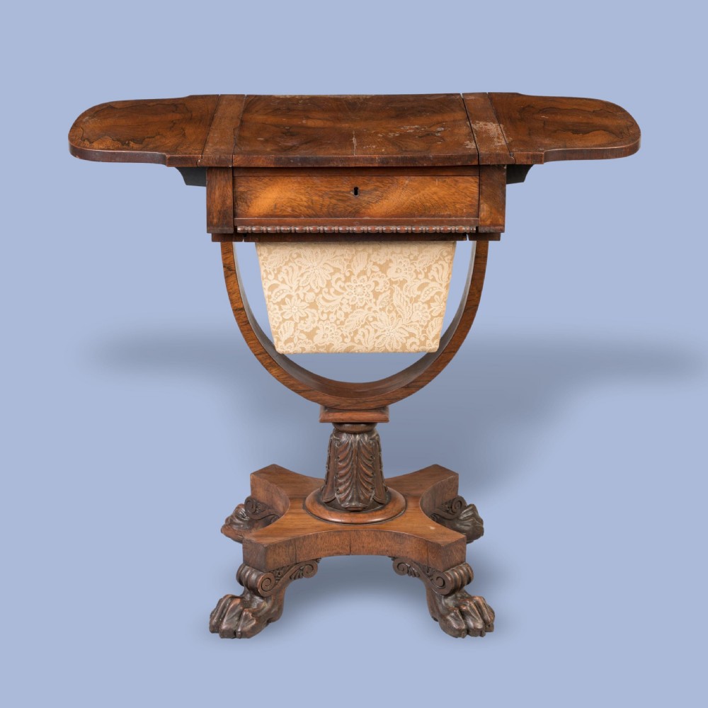 A William IV rosewood drop-leaf table with a fabric-covered work basket, U-shaped support, and carved claw feet. View IV