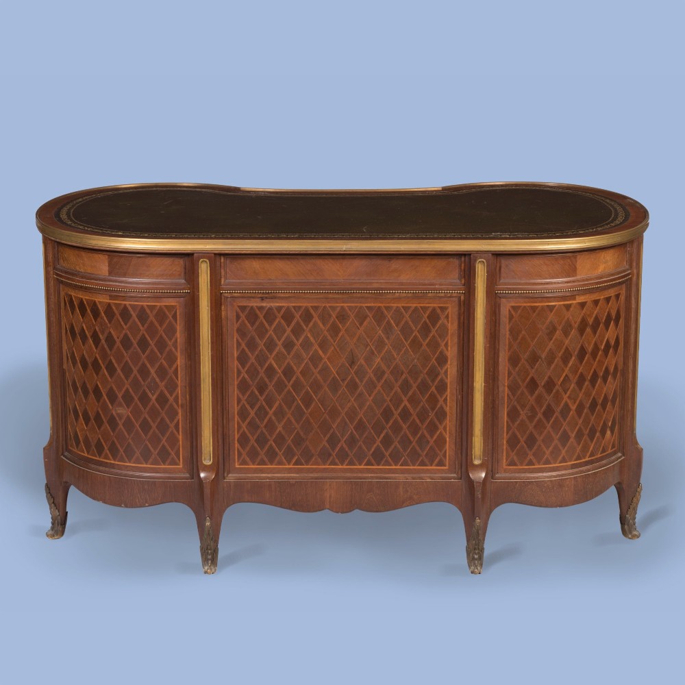 A kidney-shaped wooden writing desk featuring floral marquetry panels, gilt-bronze ormolu mounts, and a dark leather inset top with gold tooling. View III