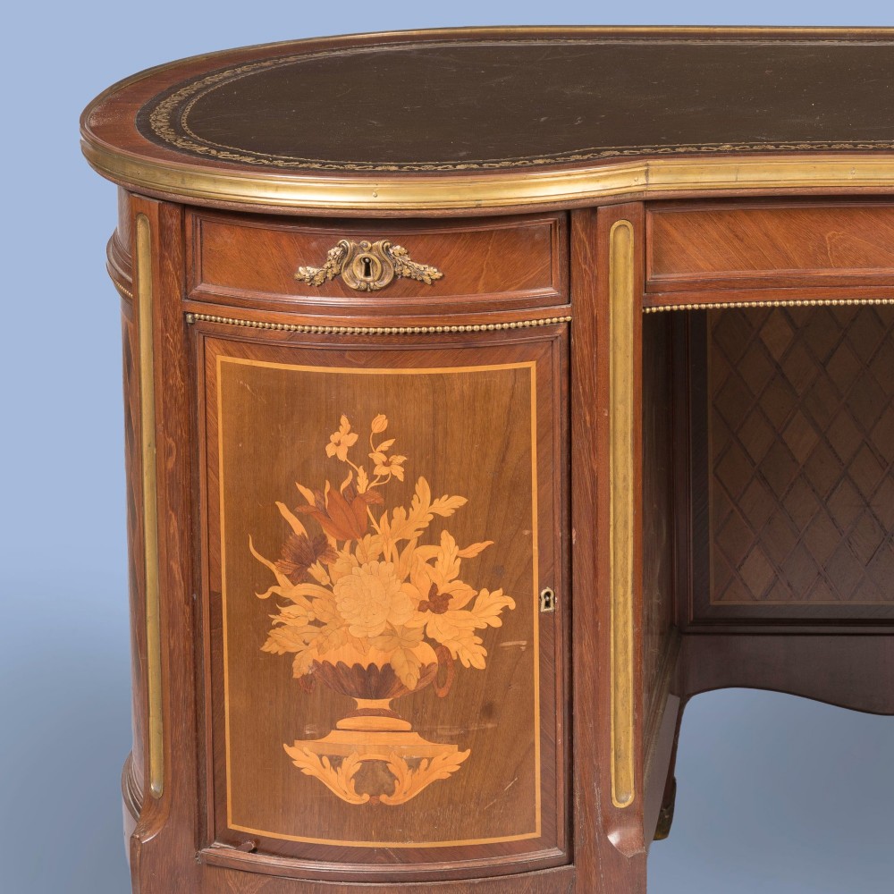 A kidney-shaped wooden writing desk featuring floral marquetry panels, gilt-bronze ormolu mounts, and a dark leather inset top with gold tooling. View IV