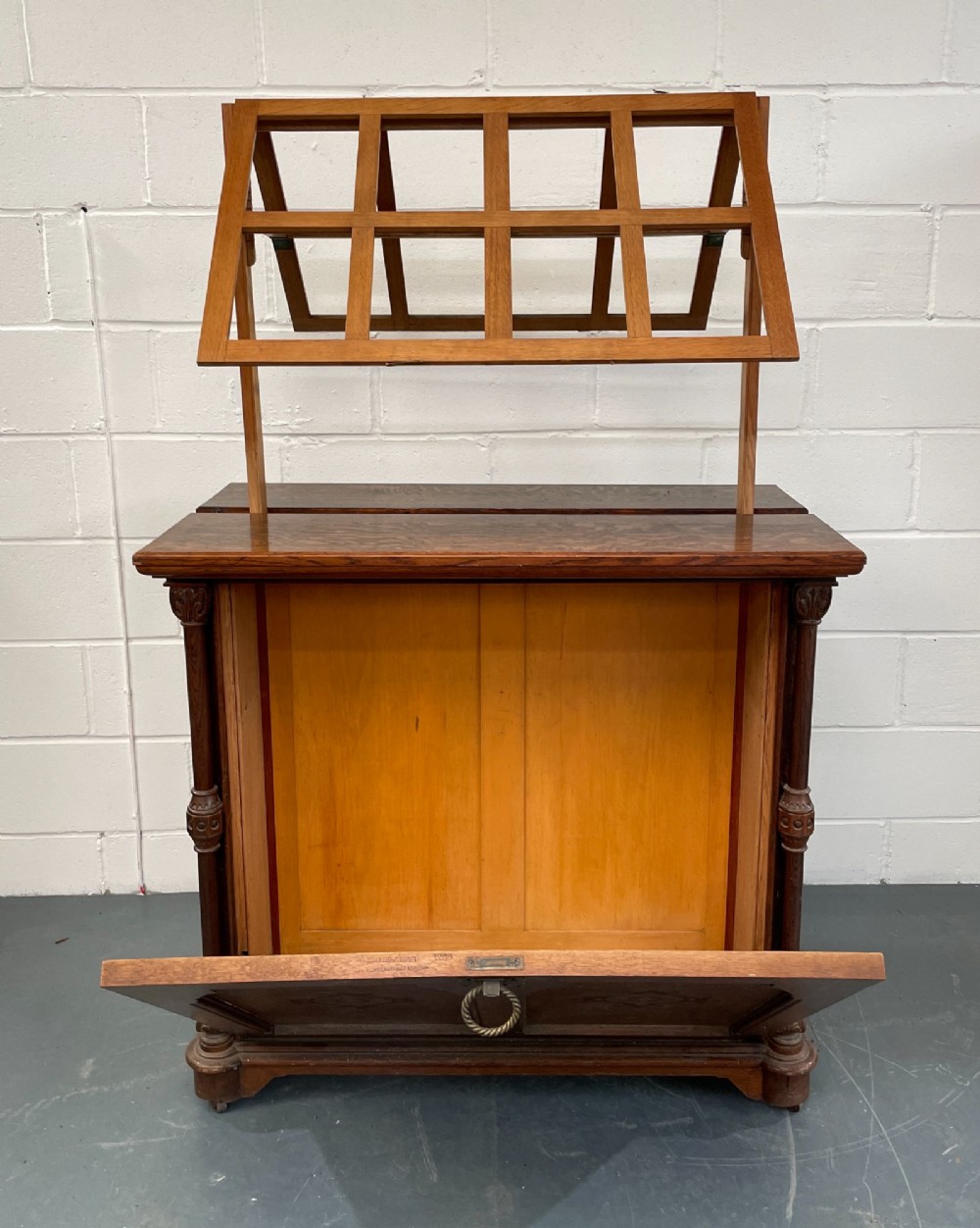 An antique Victorian Gothic Revival oak folio cabinet featuring geometric timber inlay on twin panel doors beneath an adjustable slatted display frame. View VIII