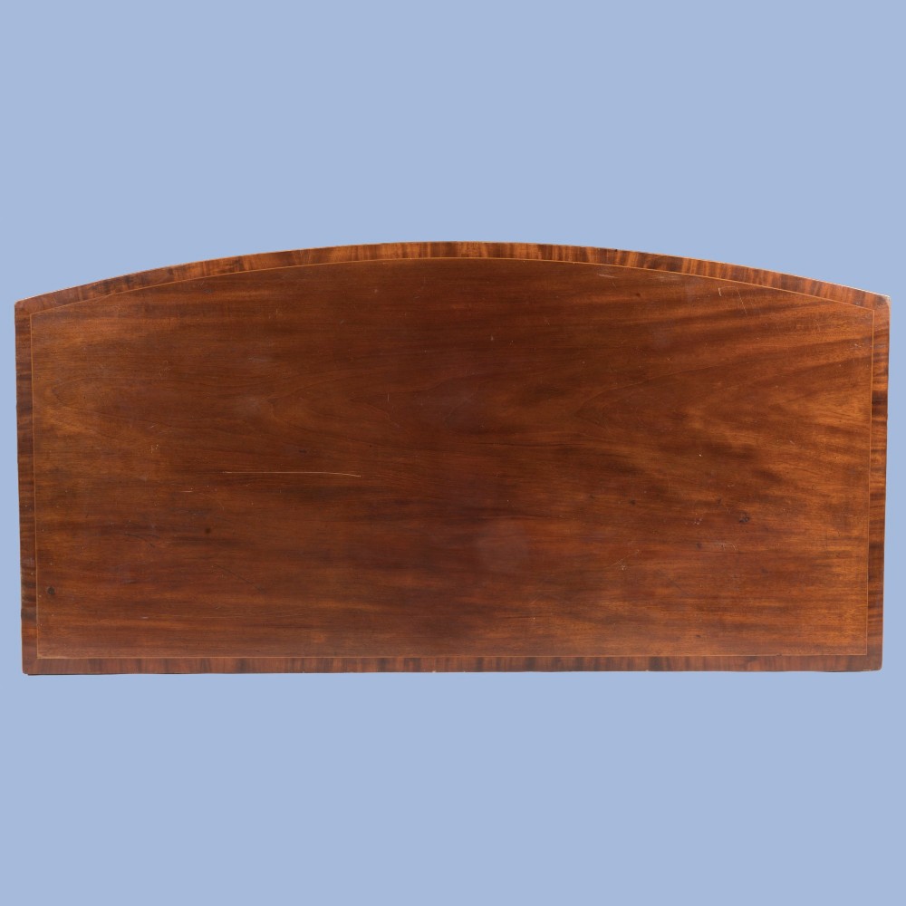 A Georgian Hepplewhite style flame mahogany sideboard featuring five drawers with brass ring handles, tapered square legs, and spade feet set against a light background. View V
