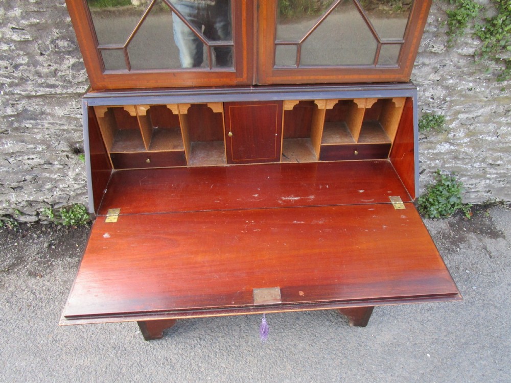An antique mahogany bureau bookcase with a swan-neck pediment, geometric glazed cabinet doors, an inlaid fall-front writing slope, and three lower drawers. View III