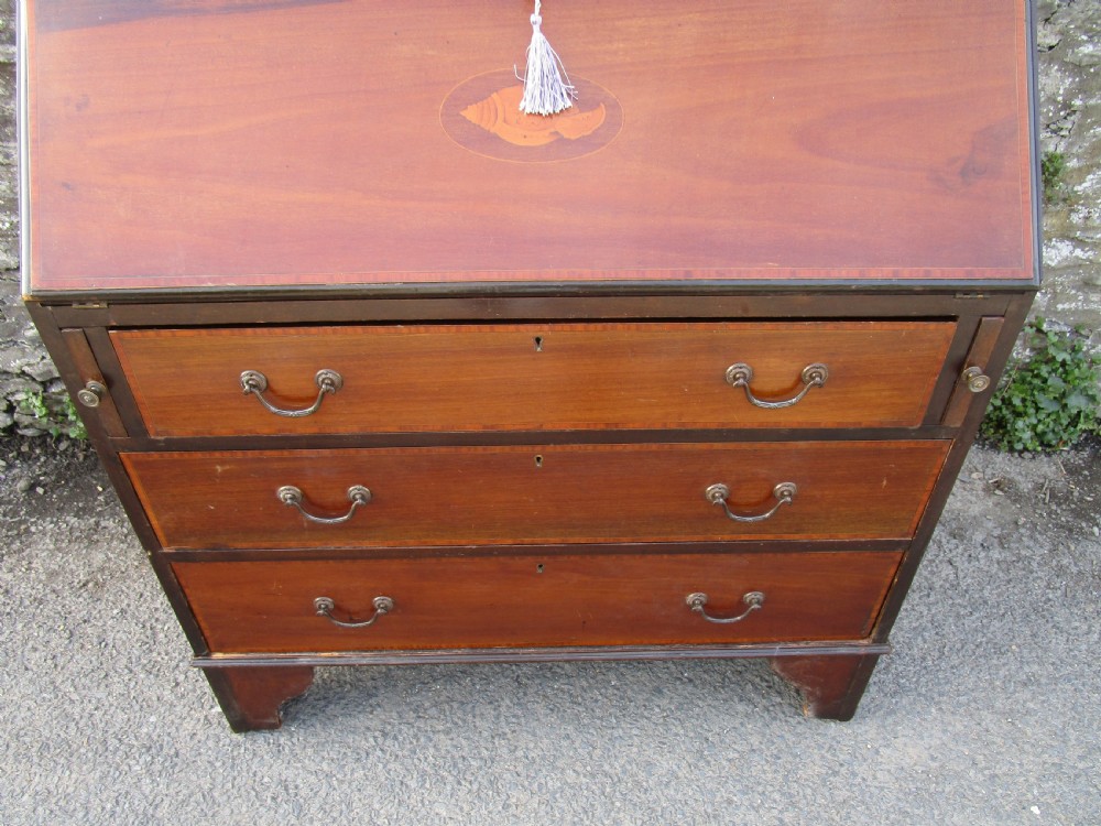 An antique mahogany bureau bookcase with a swan-neck pediment, geometric glazed cabinet doors, an inlaid fall-front writing slope, and three lower drawers. View IV