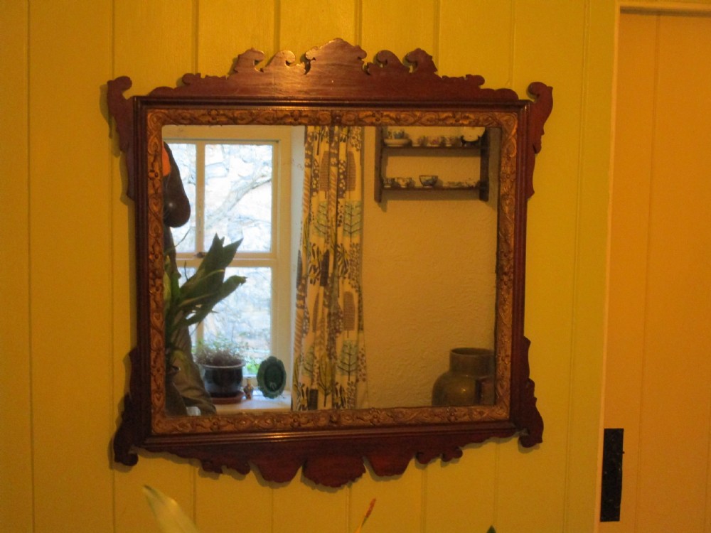A rectangular mahogany wall mirror featuring decorative fretwork scroll cresting and an inner gilded floral slip. View II