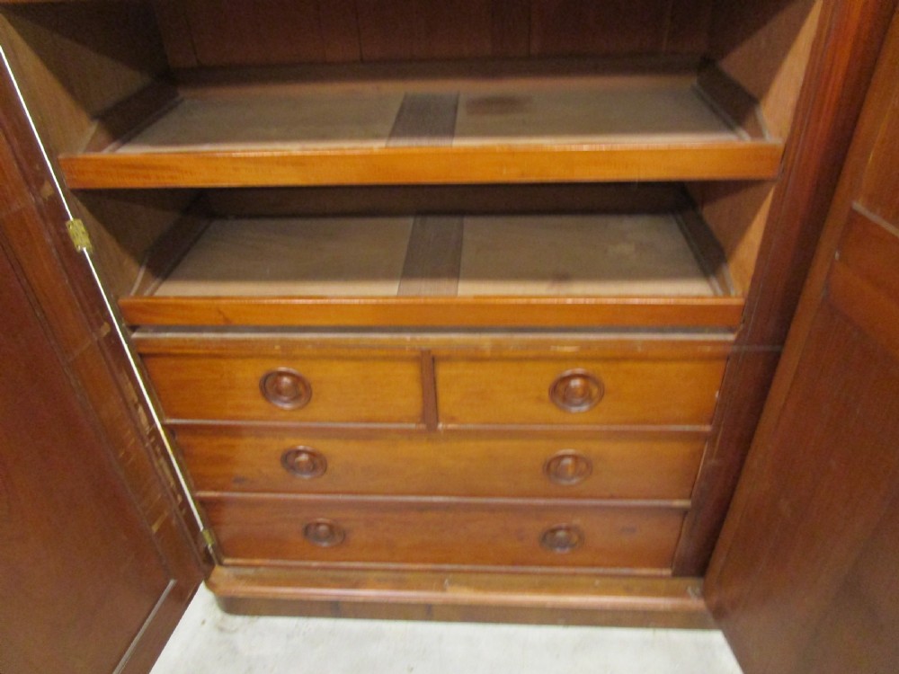 A Victorian three-door burr walnut compactum wardrobe featuring a full-length central mirror and arched panel doors set on a plinth base. View II