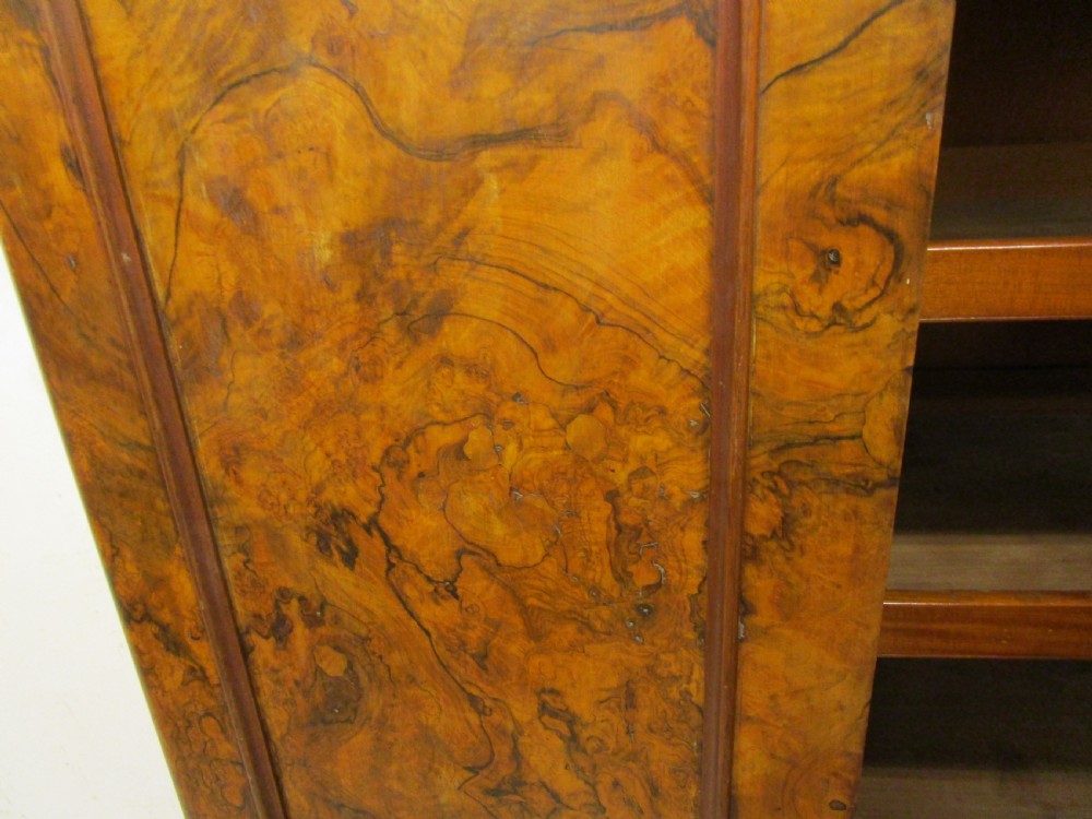 A Victorian three-door burr walnut compactum wardrobe featuring a full-length central mirror and arched panel doors set on a plinth base. View IV