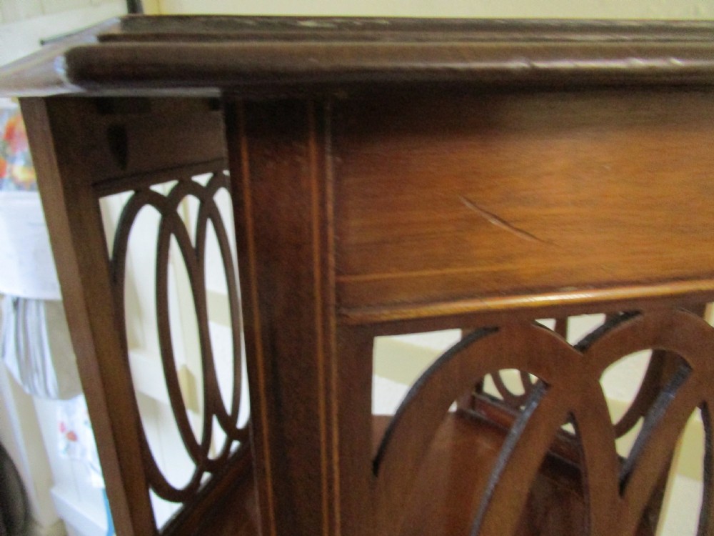 A warm brown mahogany occasional table featuring pierced fretwork side panels, a lower tier, and slender tapered legs. View III