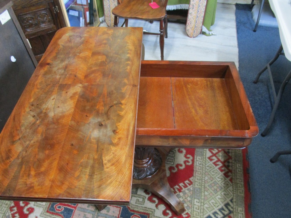 An antique timber fold-over tea table featuring a figured veneer top and a central carved pedestal base on four shaped legs. View IV