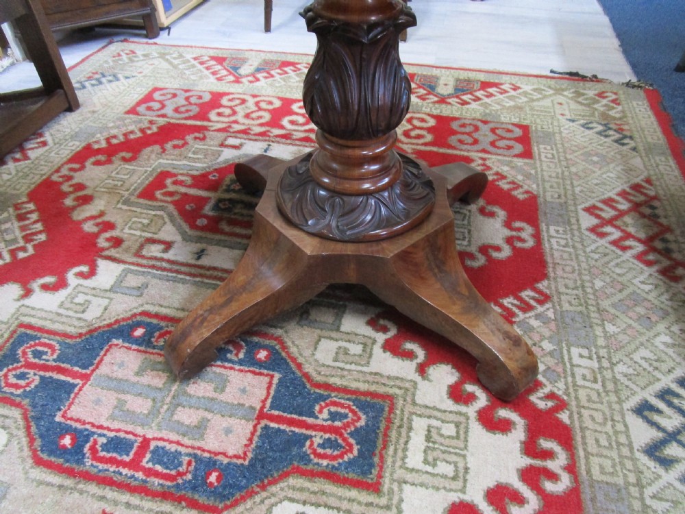 An antique timber fold-over tea table featuring a figured veneer top and a central carved pedestal base on four shaped legs. View V