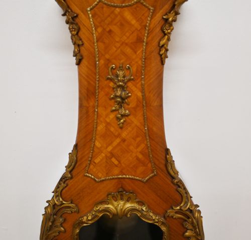 fig 1. A French longcase clock featuring a waisted kingwood veneer body with gilt-bronze mounts and an enamelled dial.