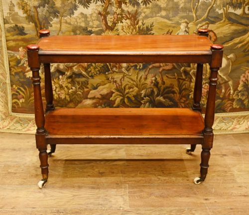 fig 1. A late 19th-century Victorian mahogany two-tier dumb waiter trolley with hand-turned legs, top finials, and ceramic castor wheels.