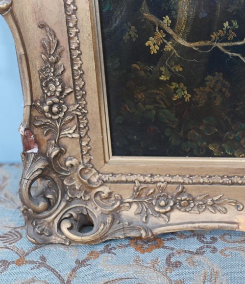 fig 2. An antique 19th-century French oil painting depicting a river landscape with trees and a distant chateau set within an ornate gilded frame.