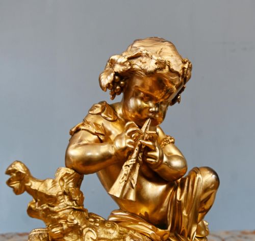 fig 3. A late 19th-century French Rococo gilt bronze mantel clock featuring a sculpted cherub playing a pipe atop, flanked by sky-blue painted porcelain plaques.