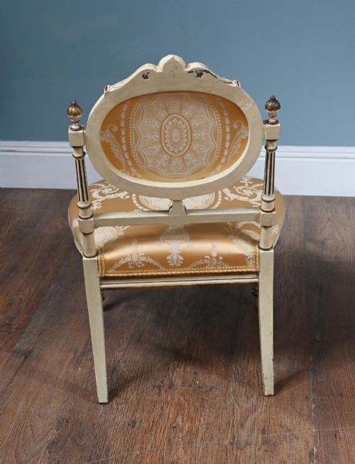 fig 2. A pair of French Neoclassical side chairs featuring painted off-white frames with fluted legs, oval medallion backs, and gold patterned silk upholstery.