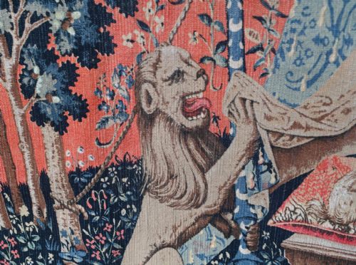 fig 2. A woven wall tapestry depicting a central female figure beside a tent inscribed Mon Seul Desir, surrounded by a lion, unicorn, and mille-fleurs background.
